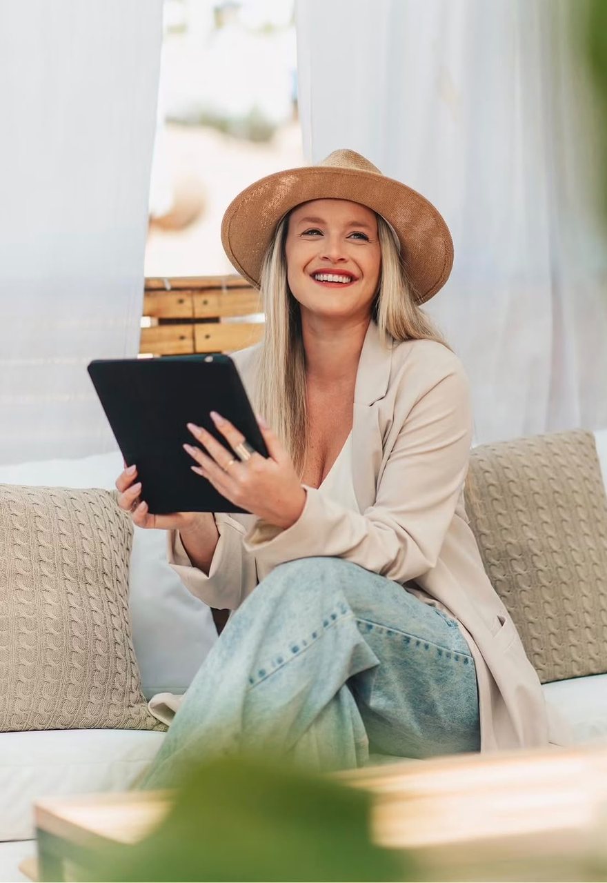 Florencia Grigera, diseñadora de interiores y fundadora de idea tu casa, sentada en un sillón exterior con una tablet